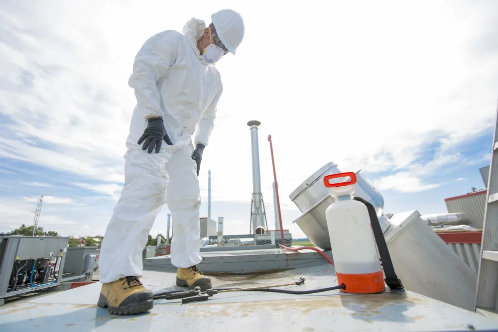 Cleaning technician beside rooftop ventilation equipment